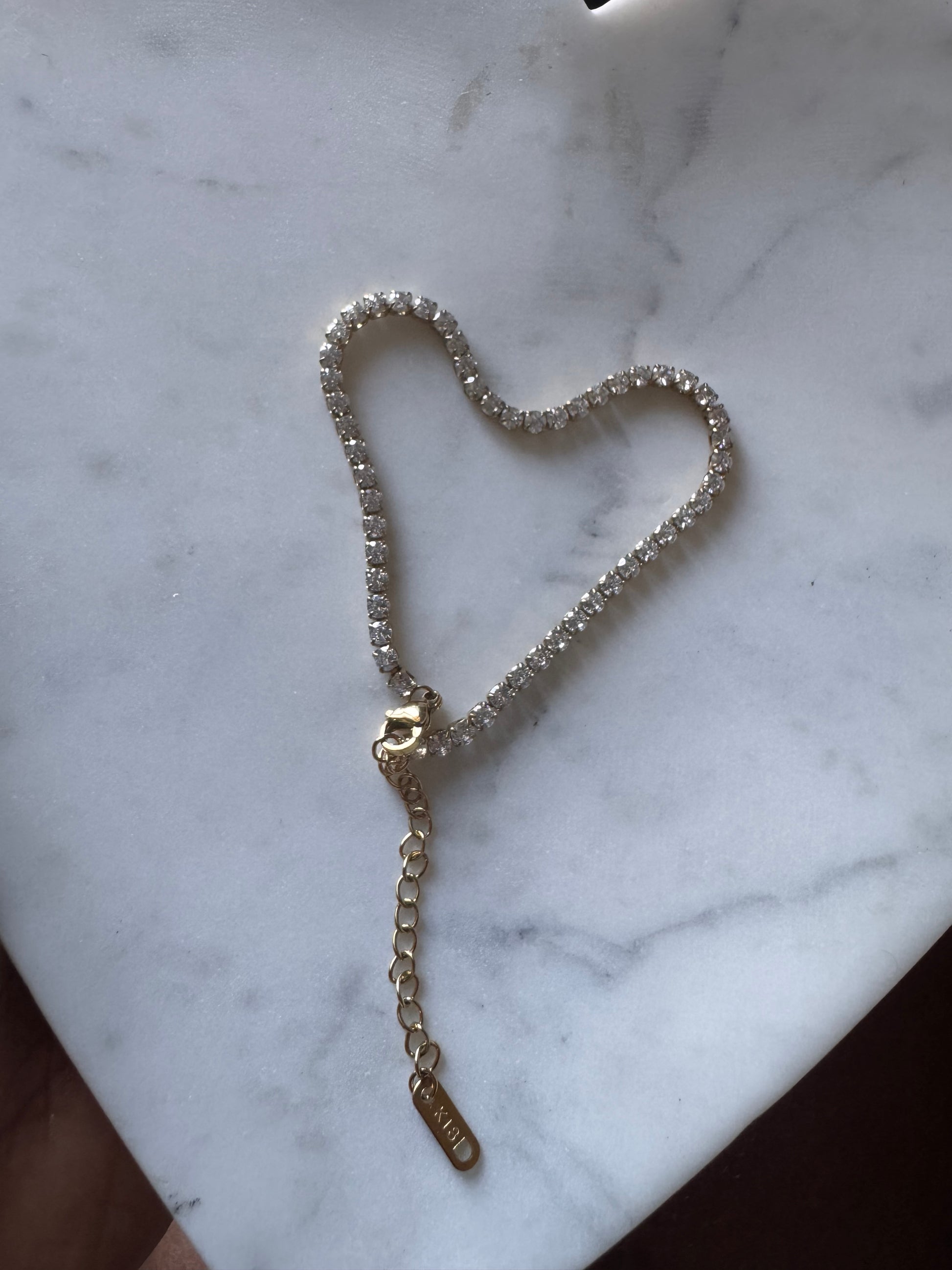 Gold anklet on a marble surface