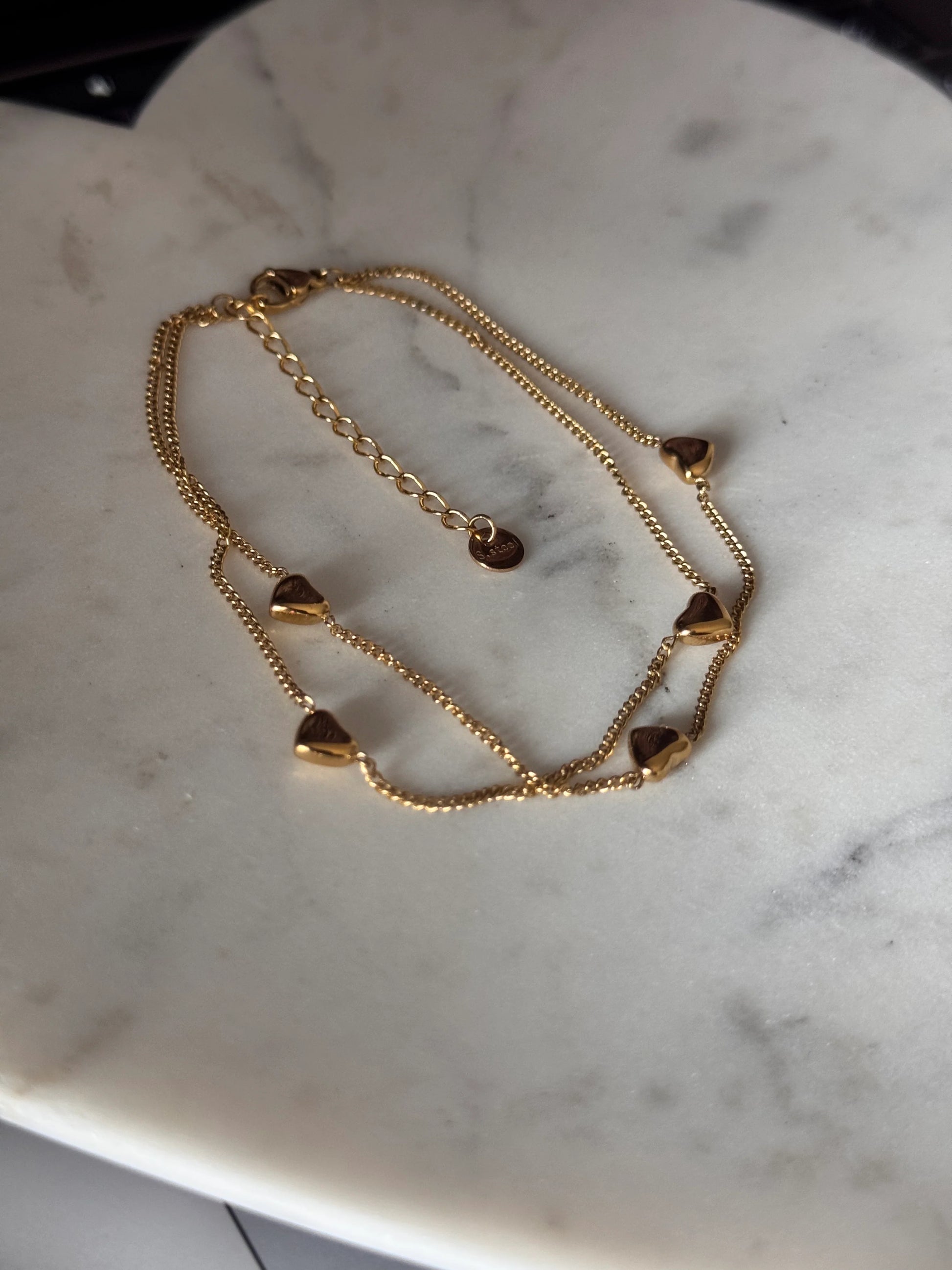 Gold chain bracelet on a marble surface