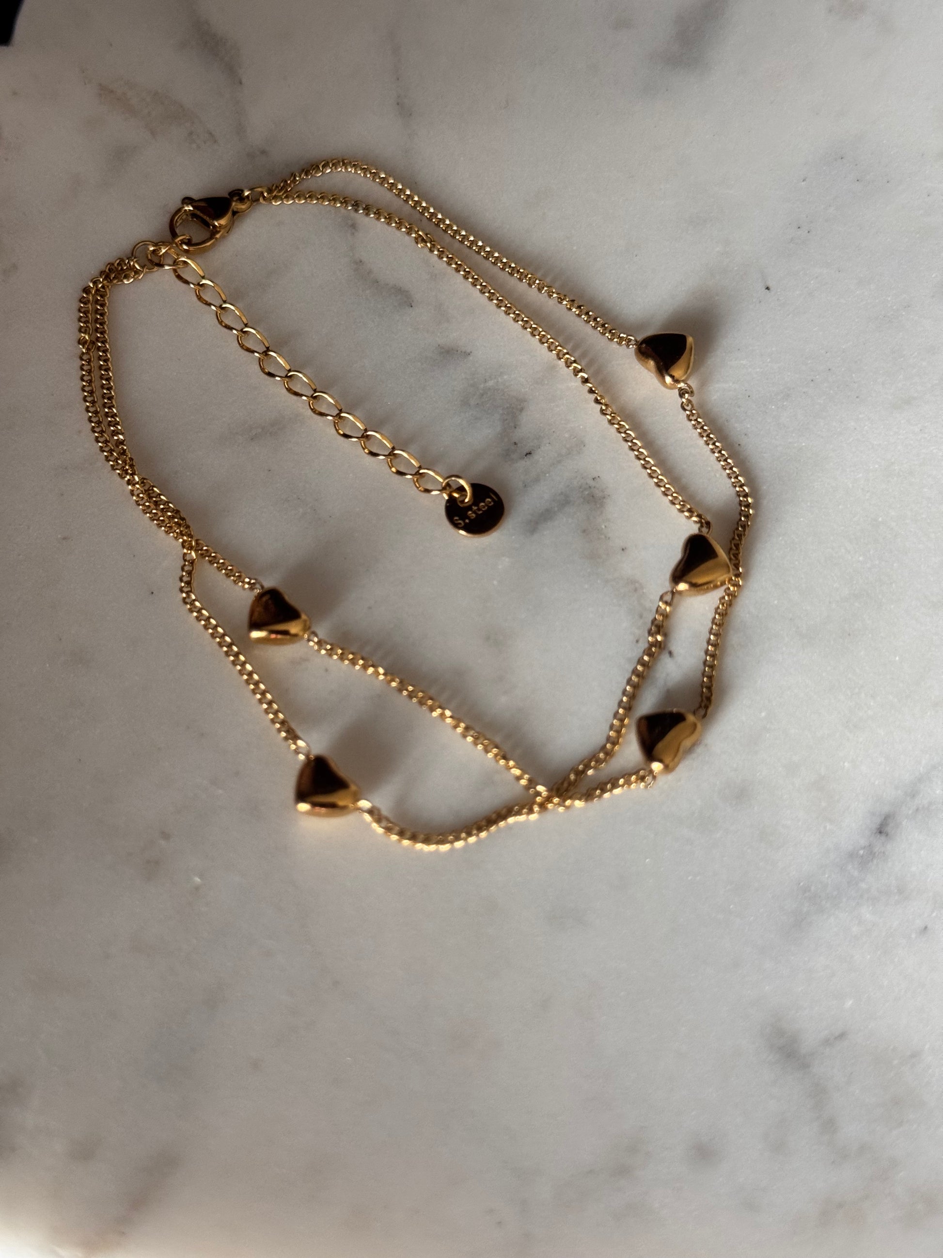 Gold chain bracelet on a marble surface