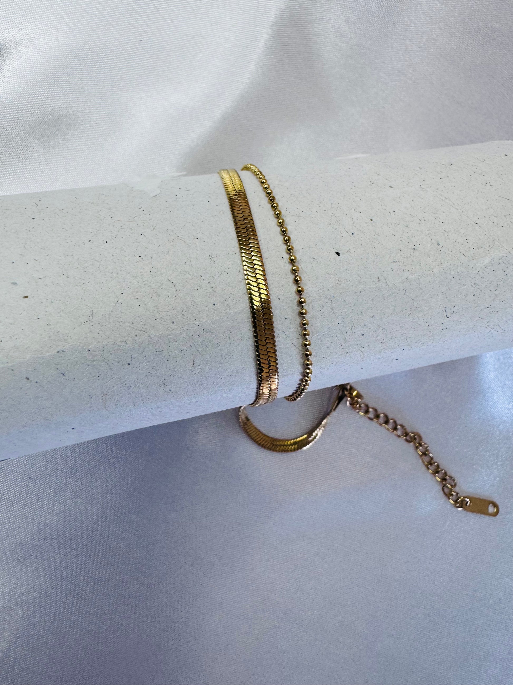 Gold bracelet on a white surface