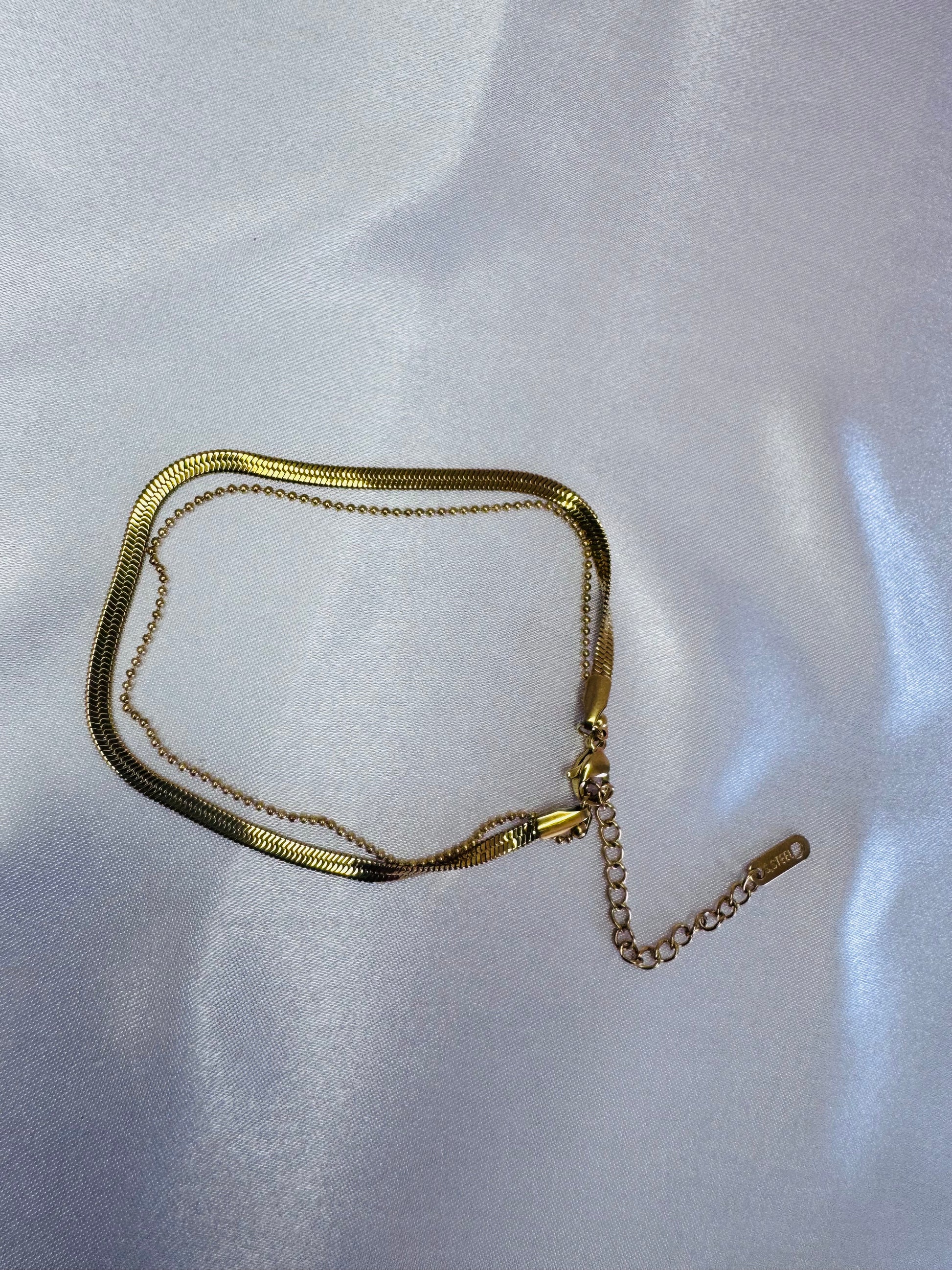 Gold bracelet on a white fabric background