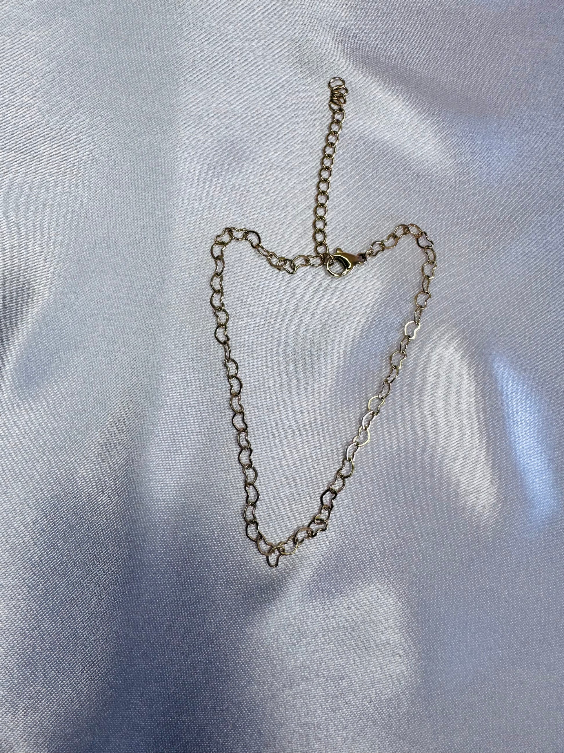 Silver chain necklace on a light gray fabric background
