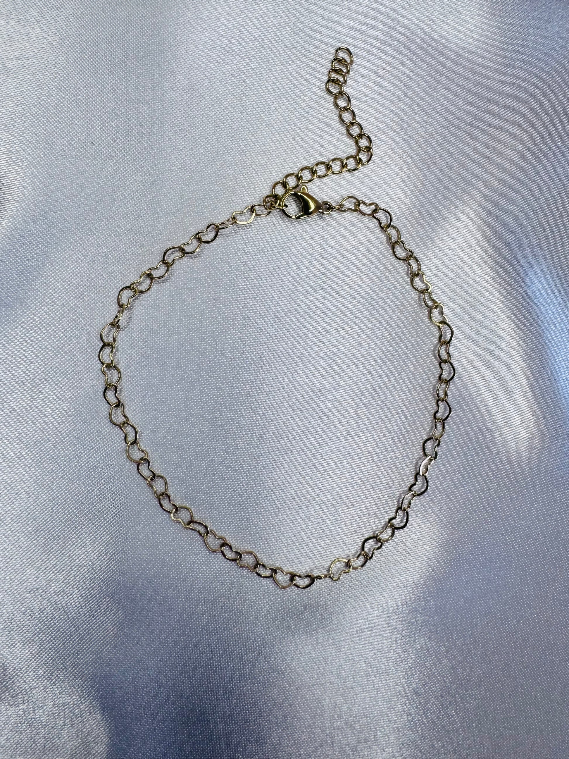 Silver chain bracelet on a reflective silver surface