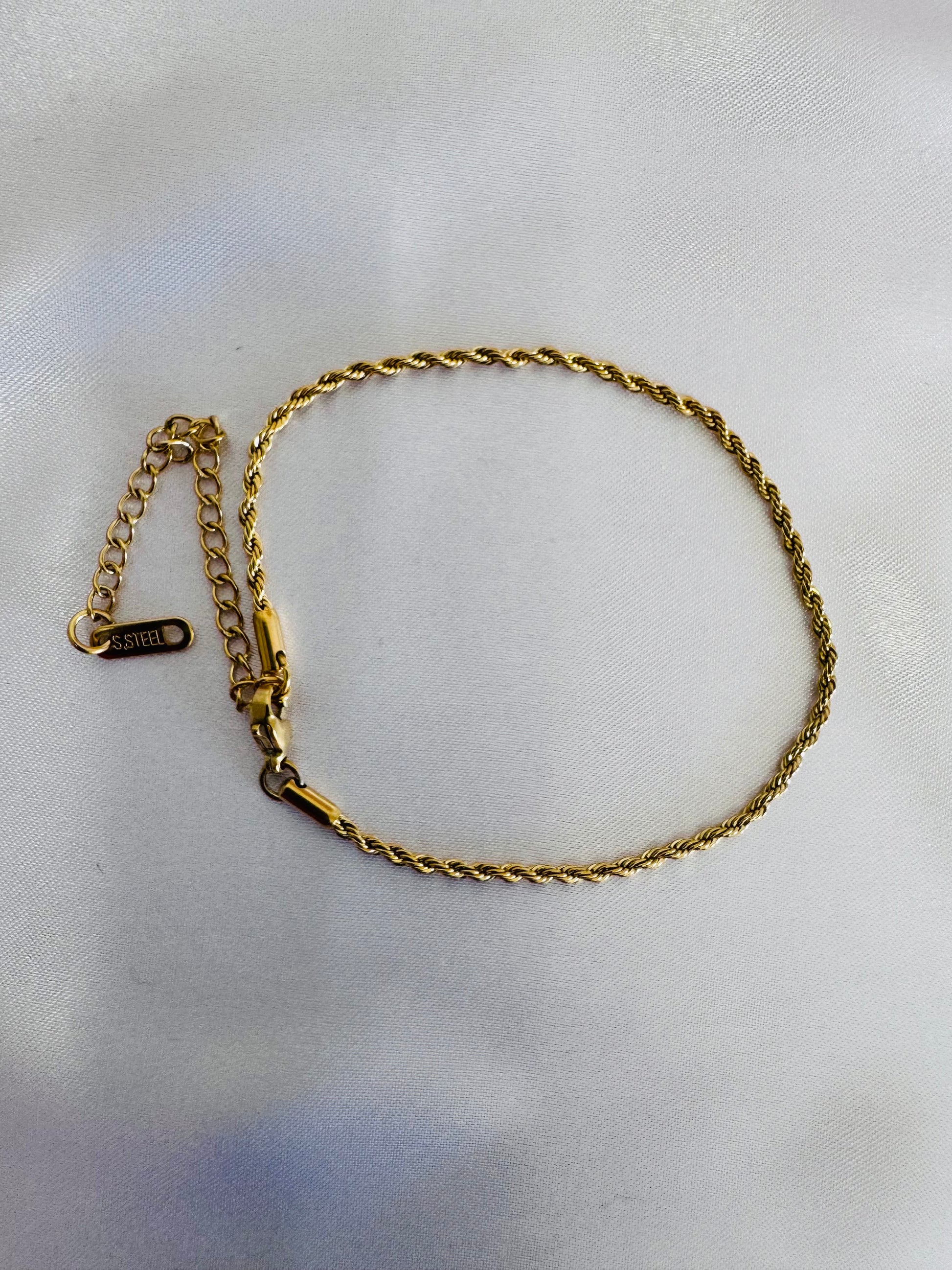 Gold rope anklet on a light gray background