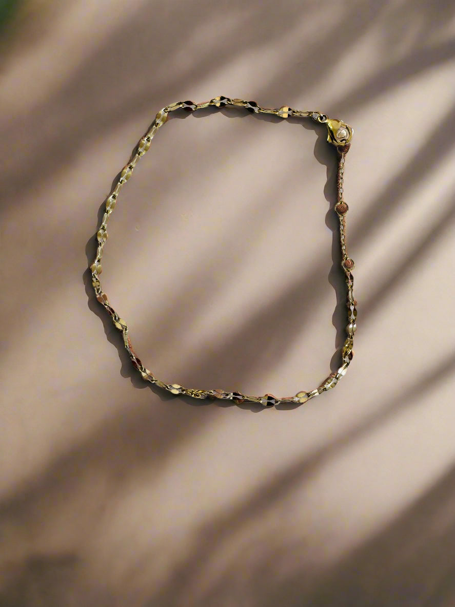 Gold twinkle anklet on a light gray background