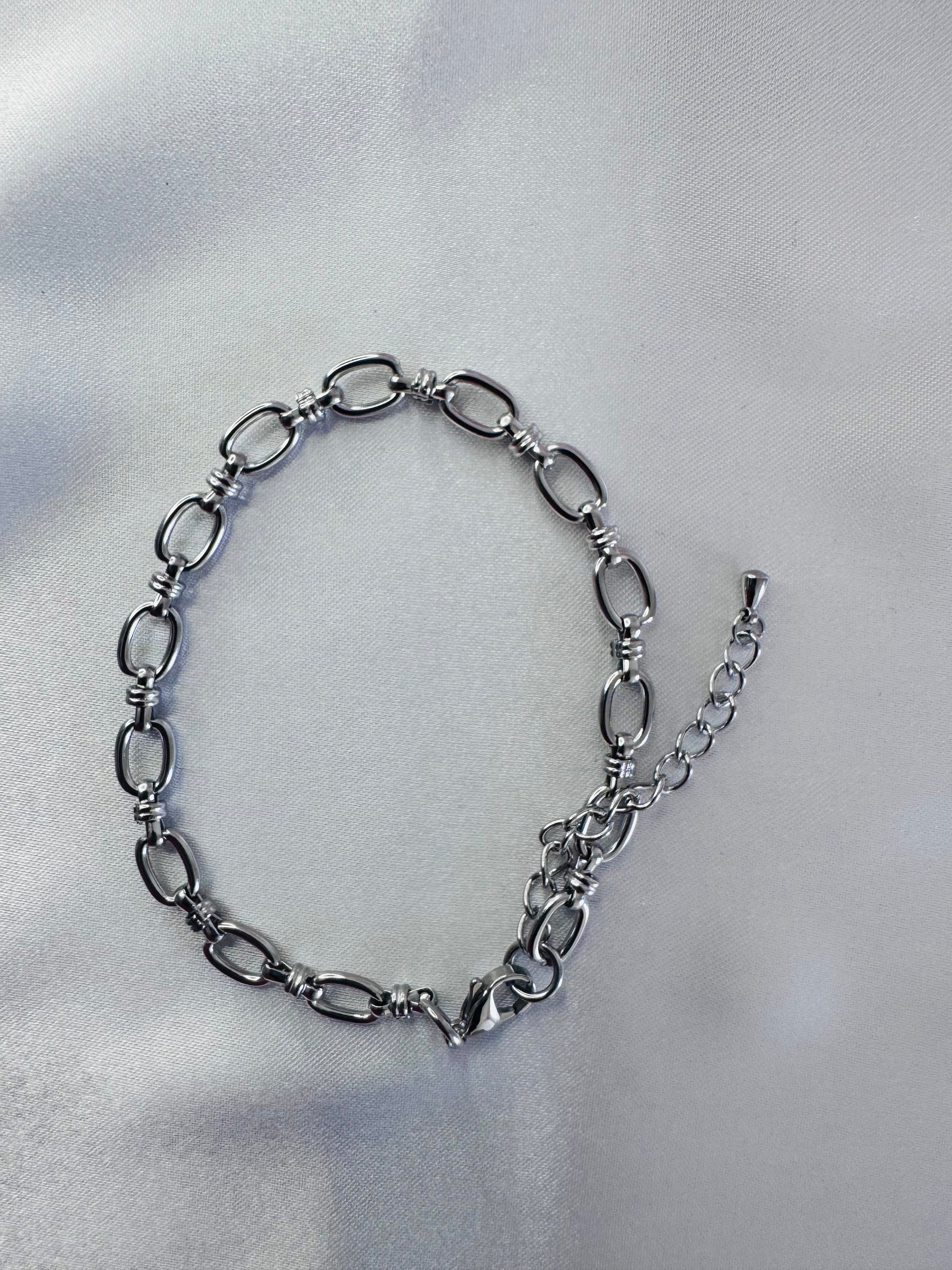 Silver anklet on a light gray background