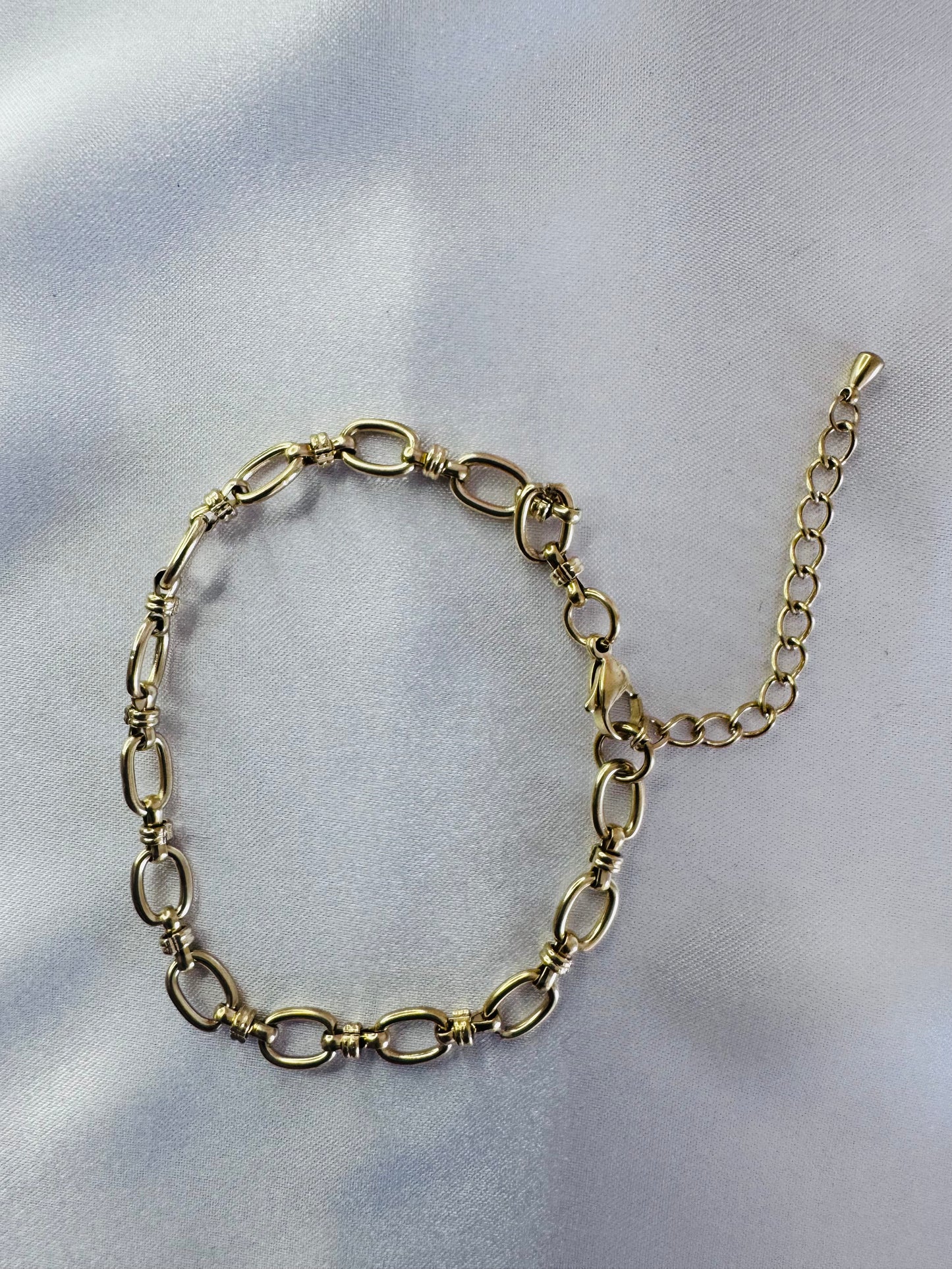 Gold anklet on a light gray background