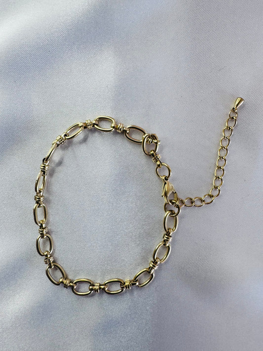 Gold anklet on a light gray background
