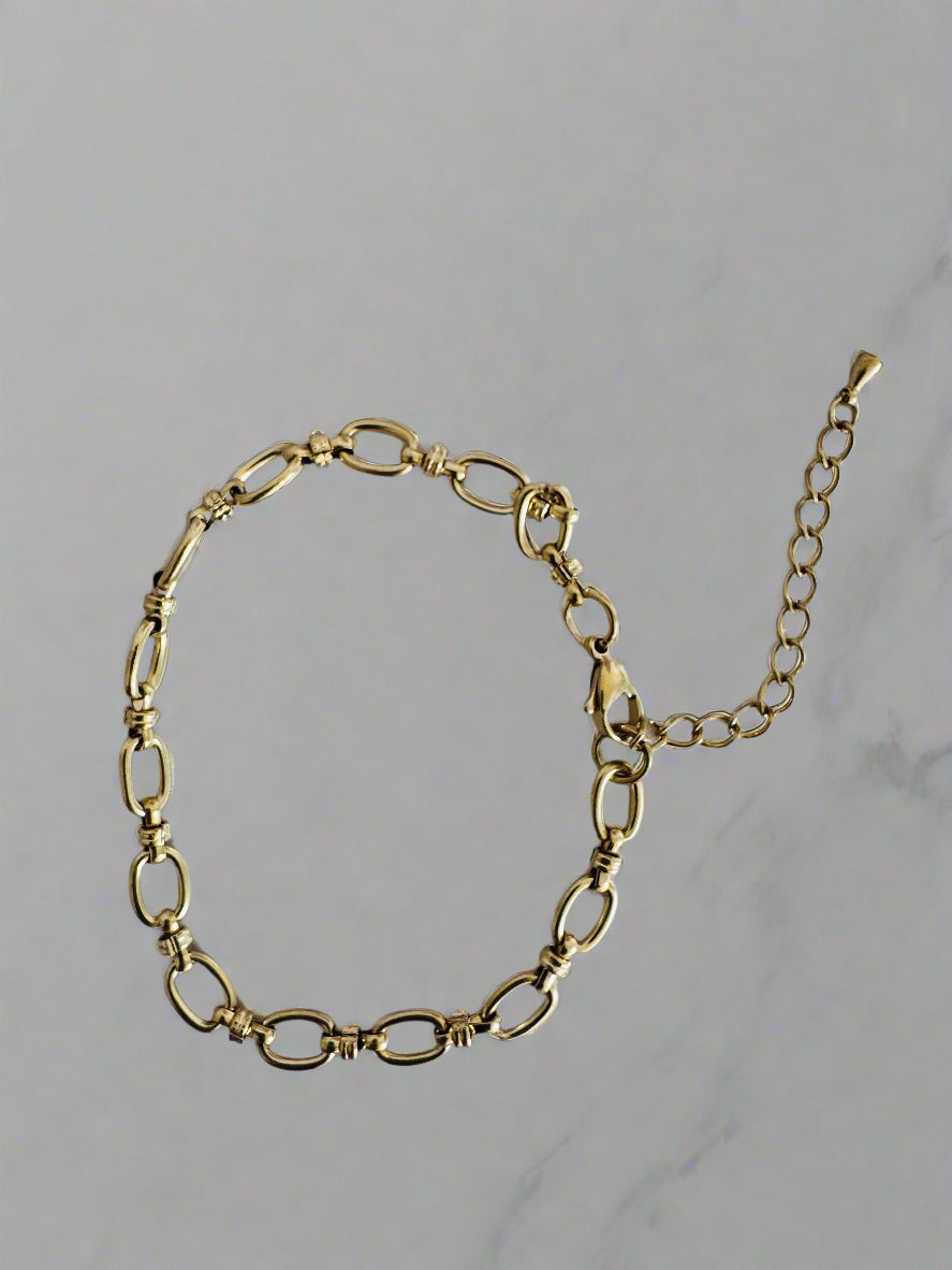 Gold anklet on a light gray background