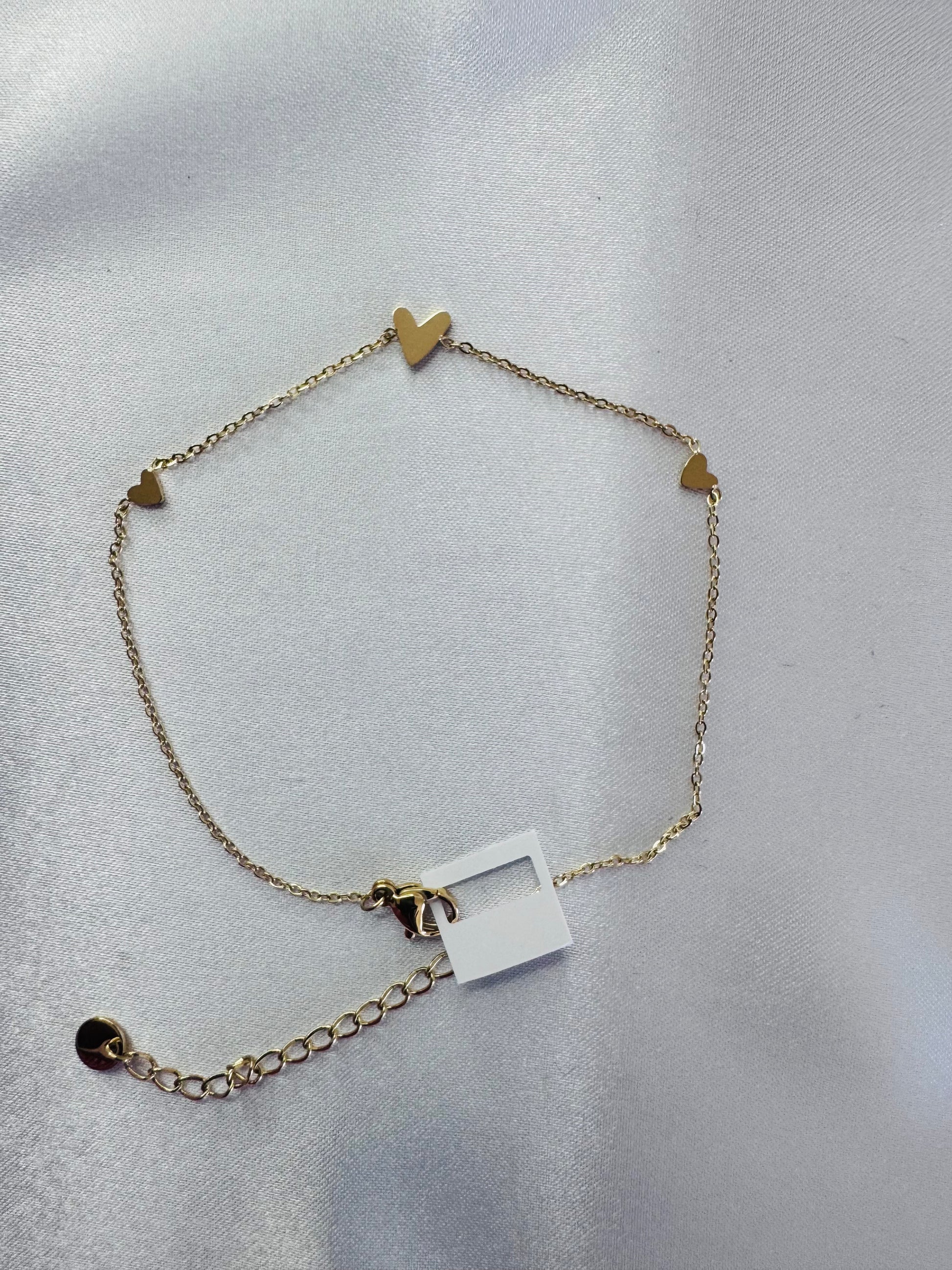 anklet with heart-shaped charms on a light gray background