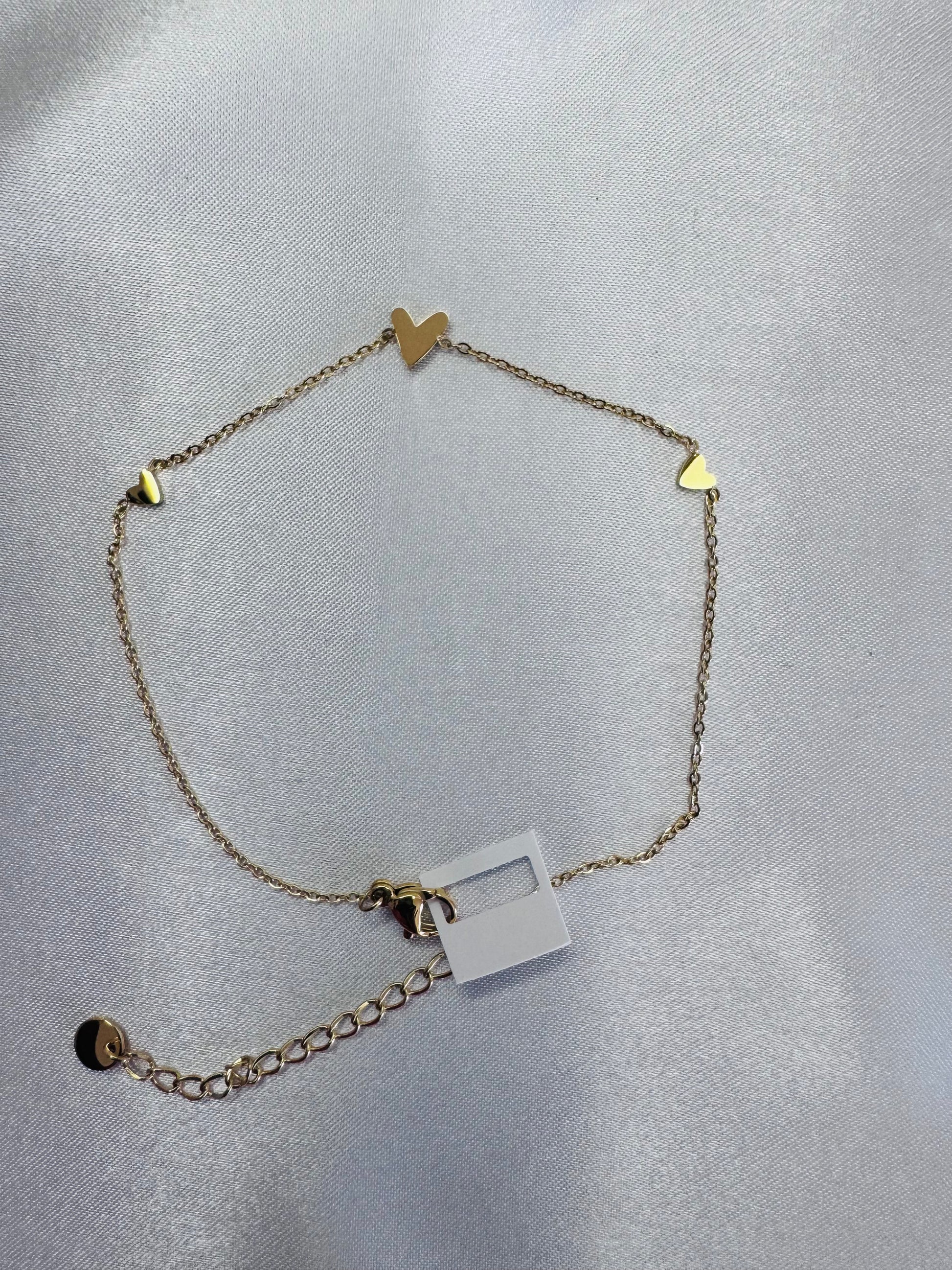 anklet  with heart and triangle charms on a light gray background