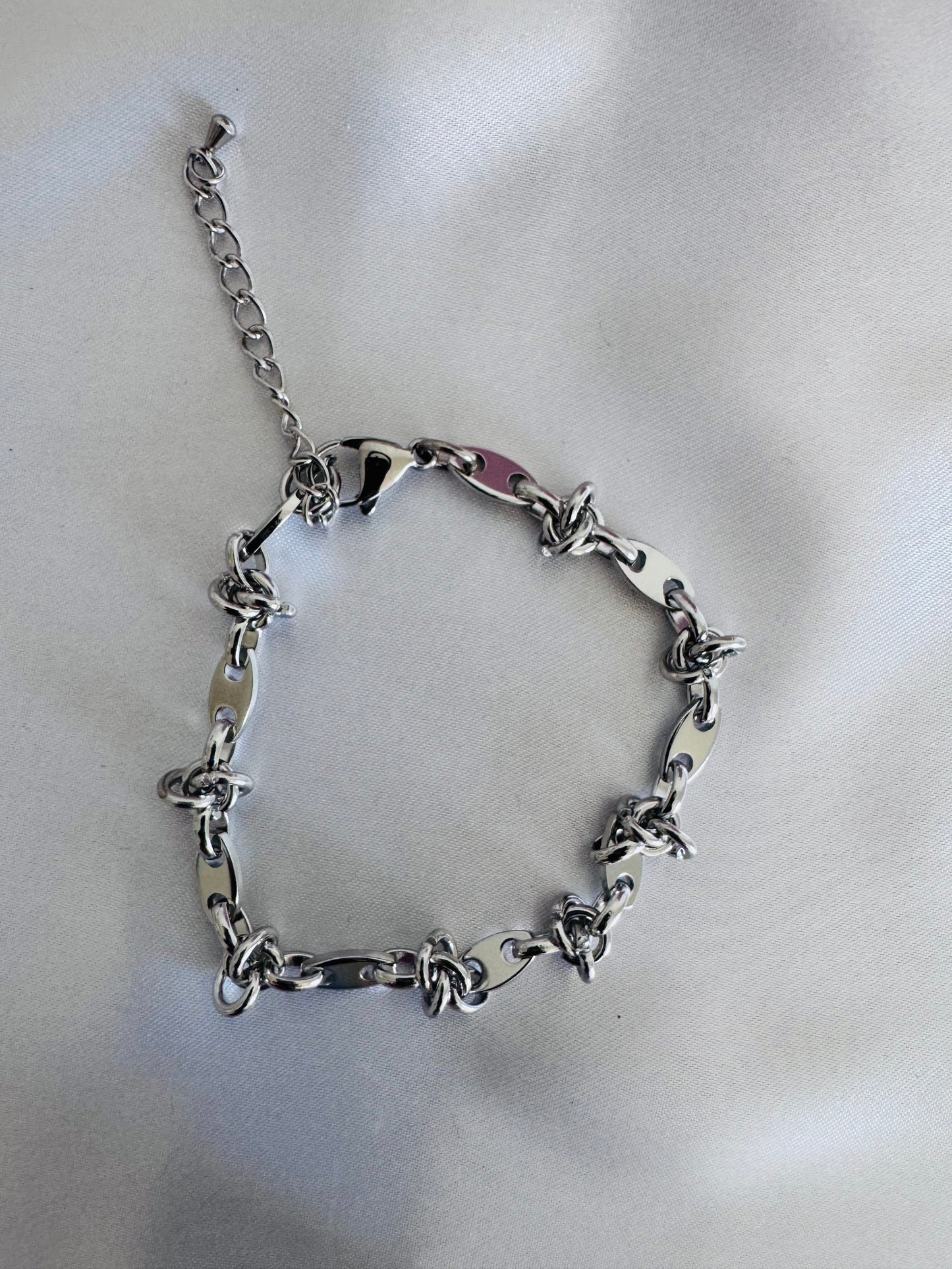 Silver chain anklet on a light gray background