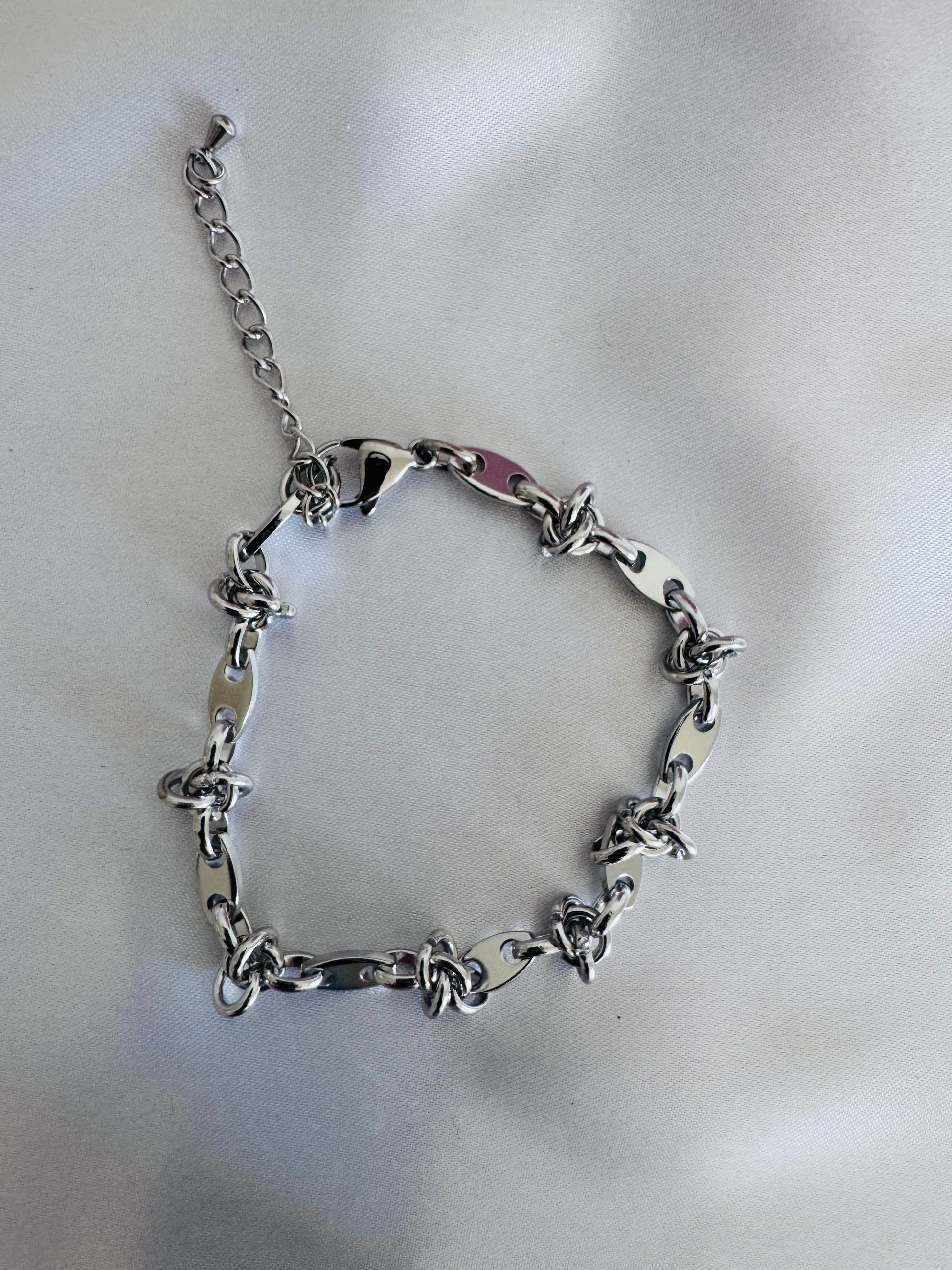 Silver chain anklet on a light gray background