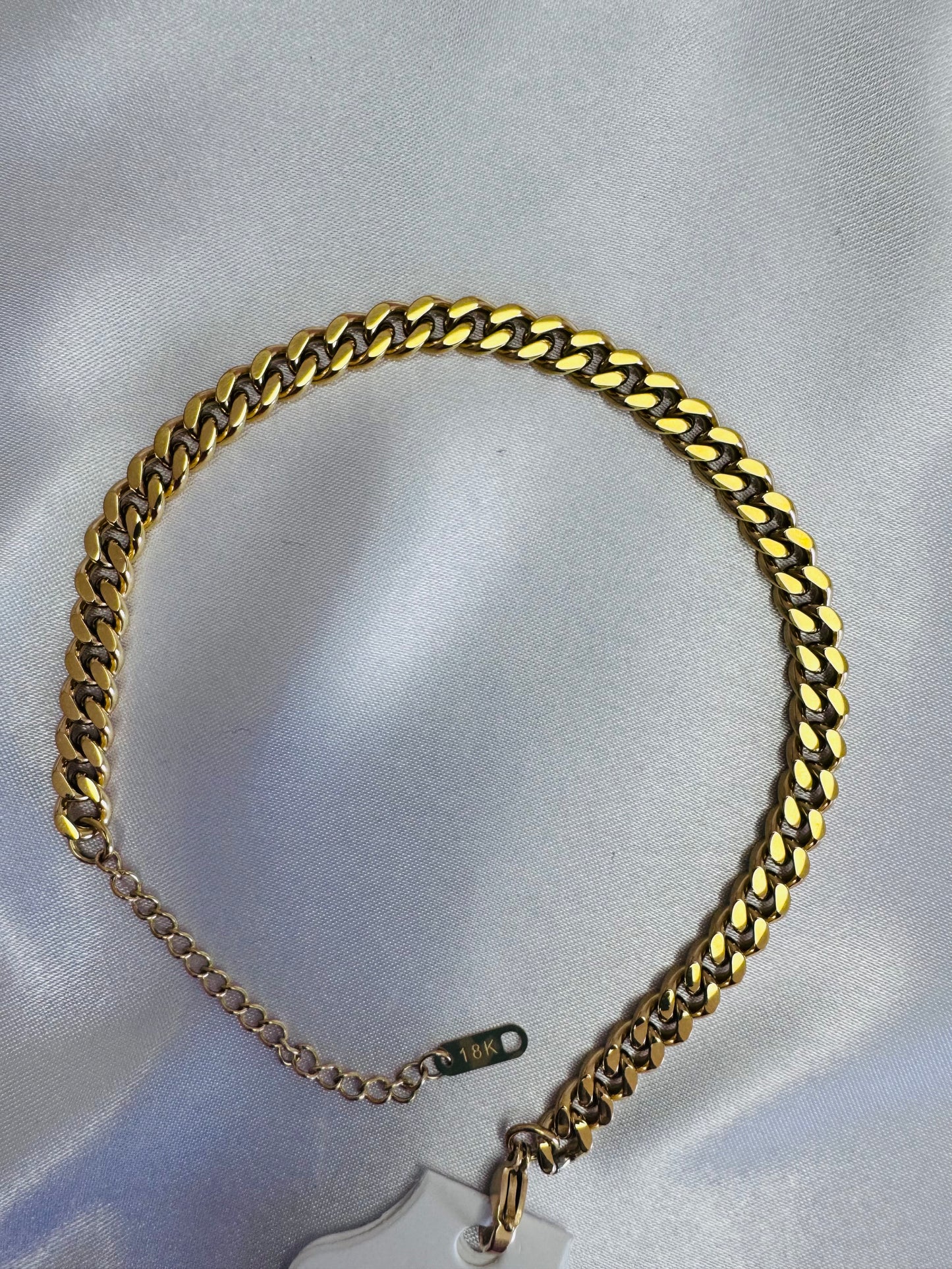 18k cuban link anklet on a light gray background