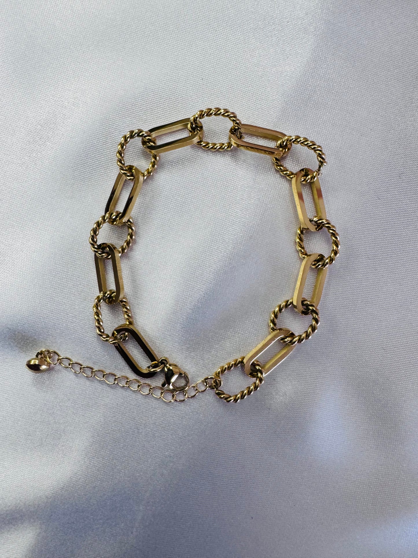 Gold rope anklet on a light gray background