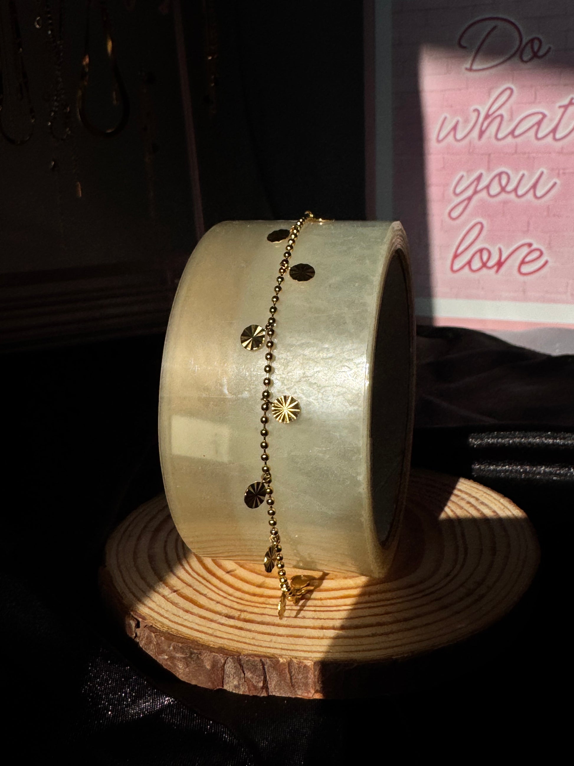 Gold anklet  on a wooden stand with a blurred background