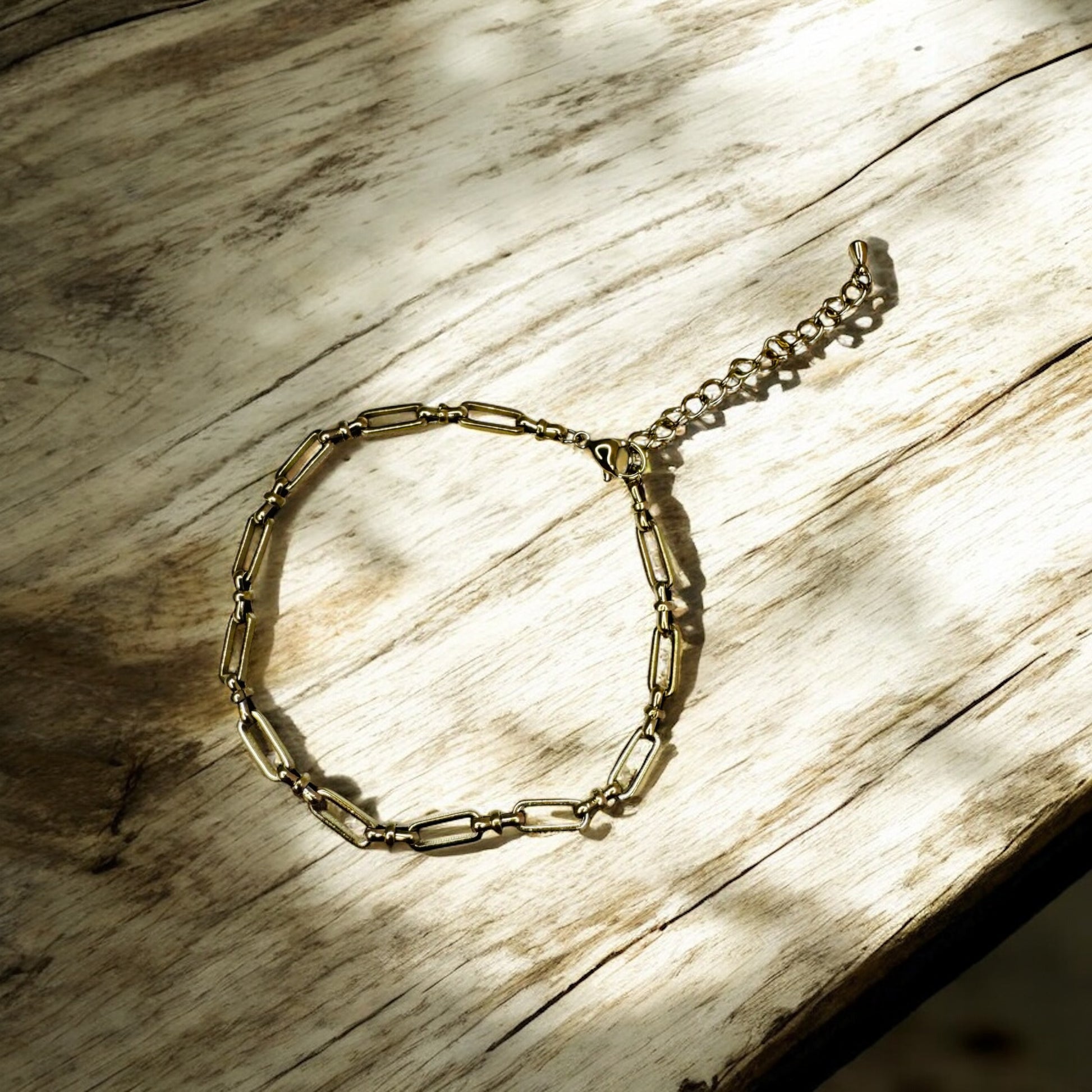 Gold bold link anklet on a wooden surface