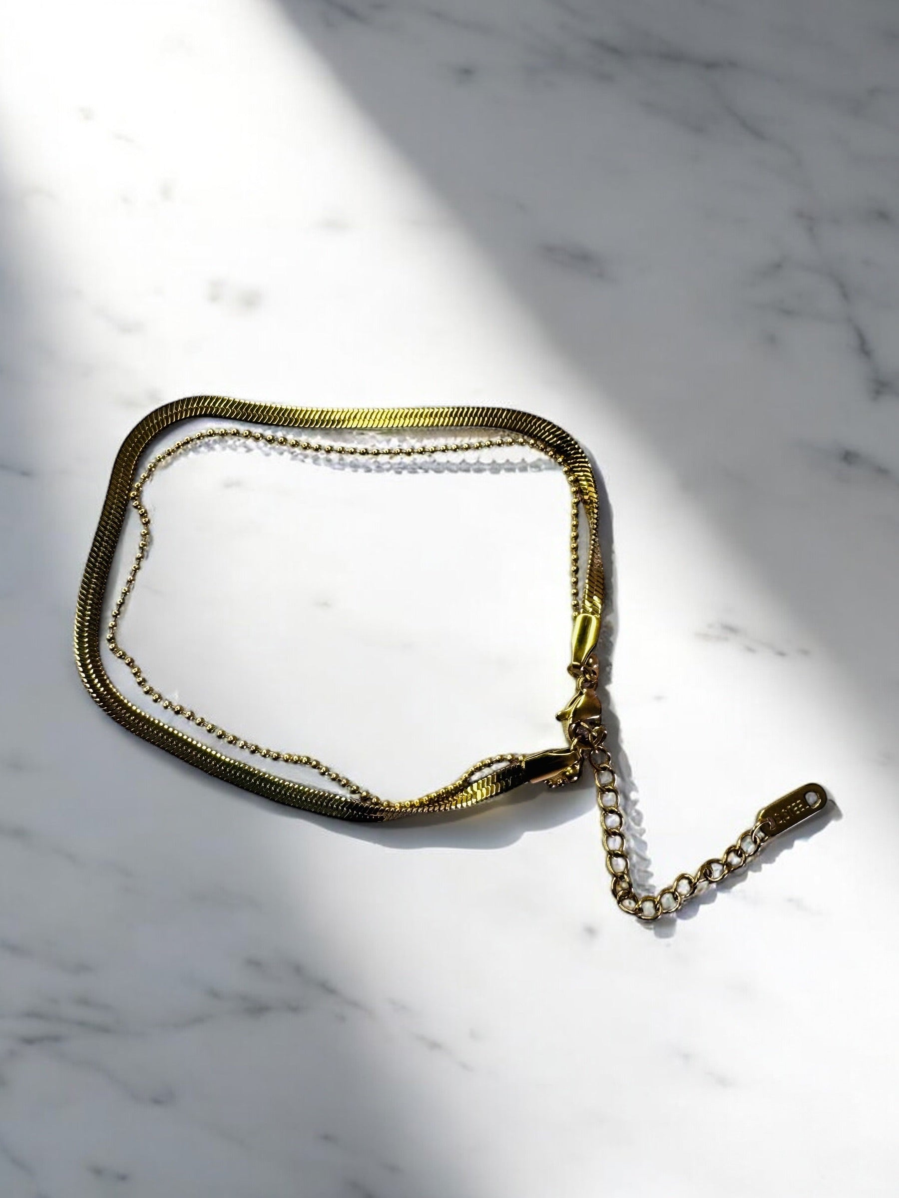 Gold chain bracelet on a marble surface