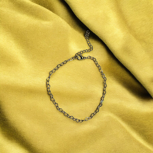 Gold chain bracelet on a yellow fabric background