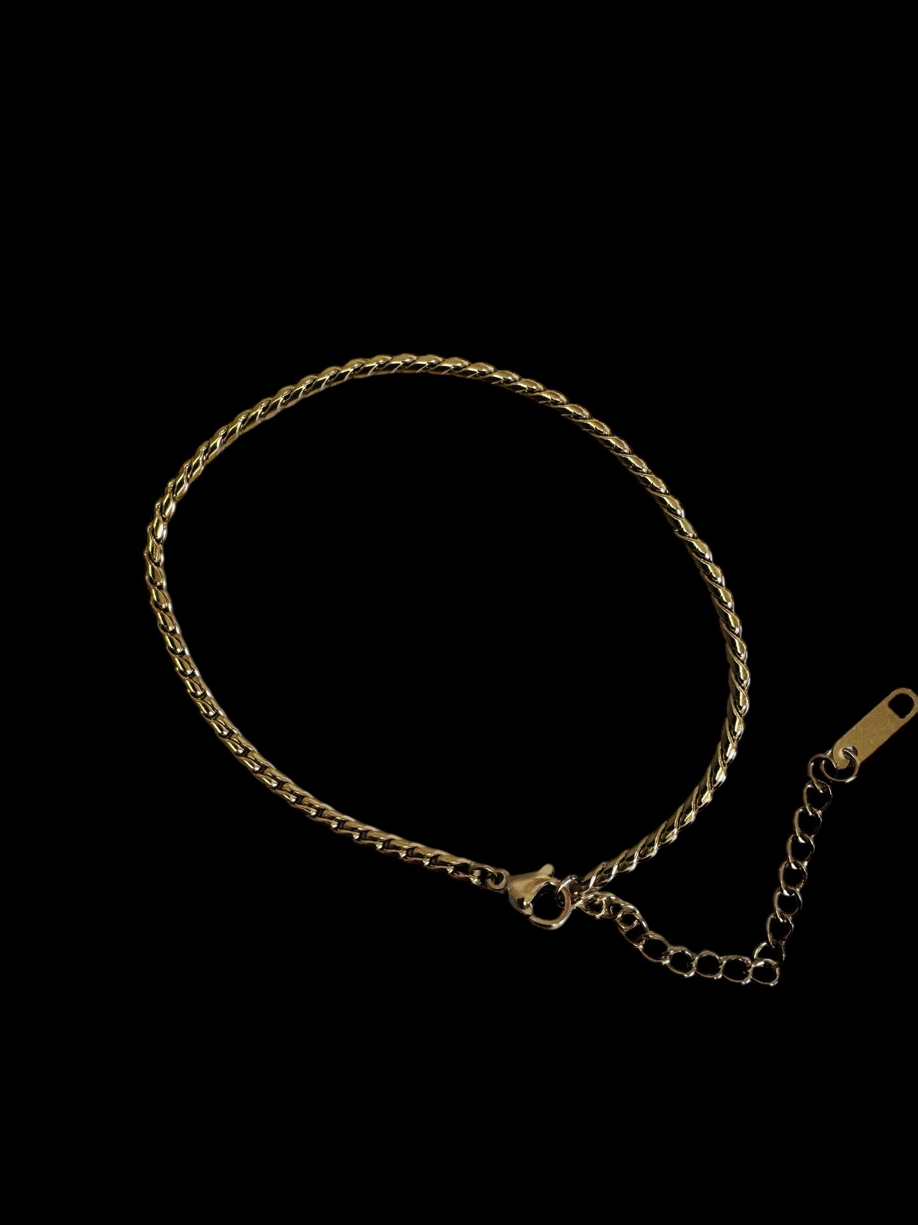 Gold twist rope anklet on a black background