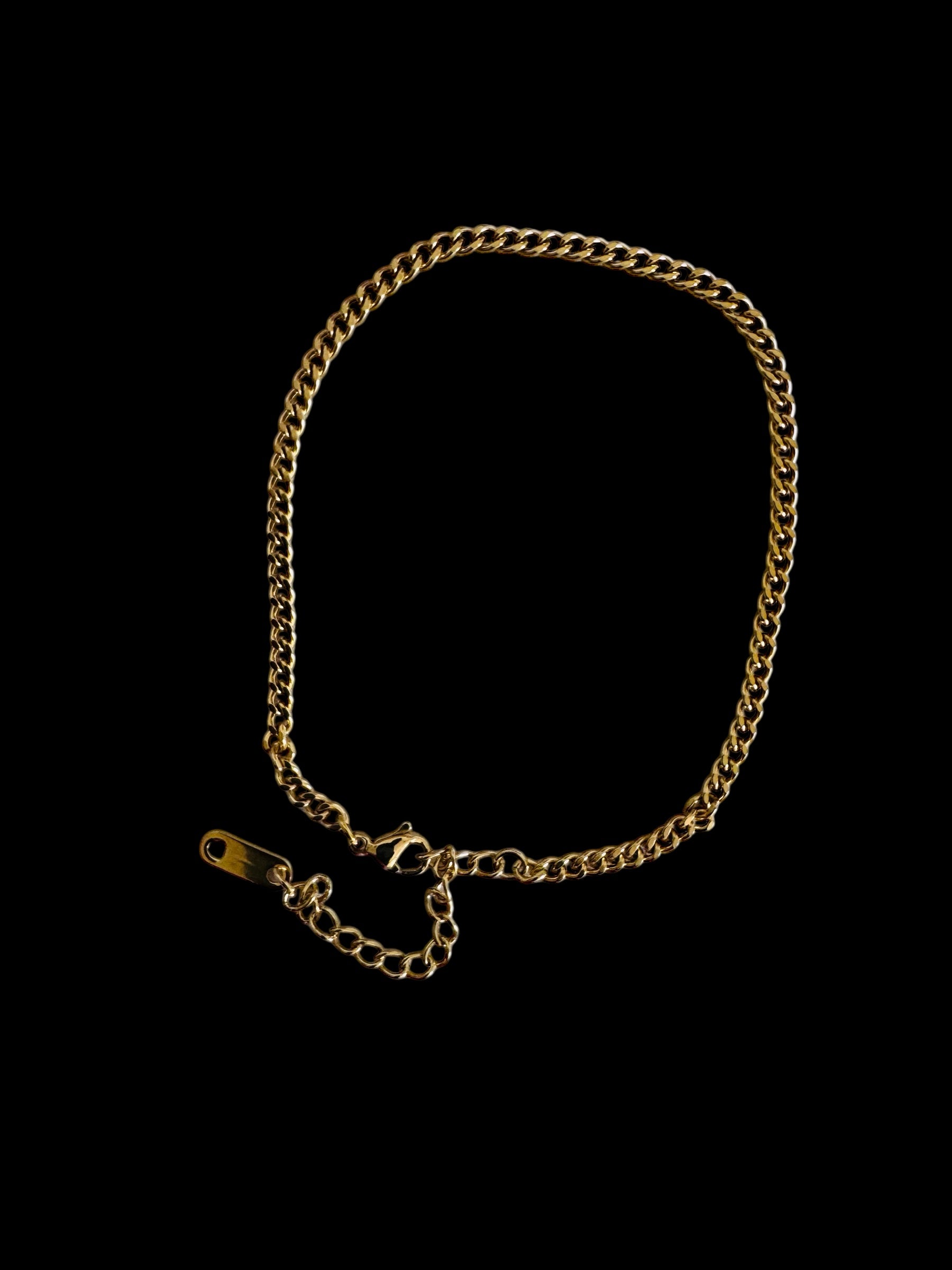 Gold chain anklet on a black background