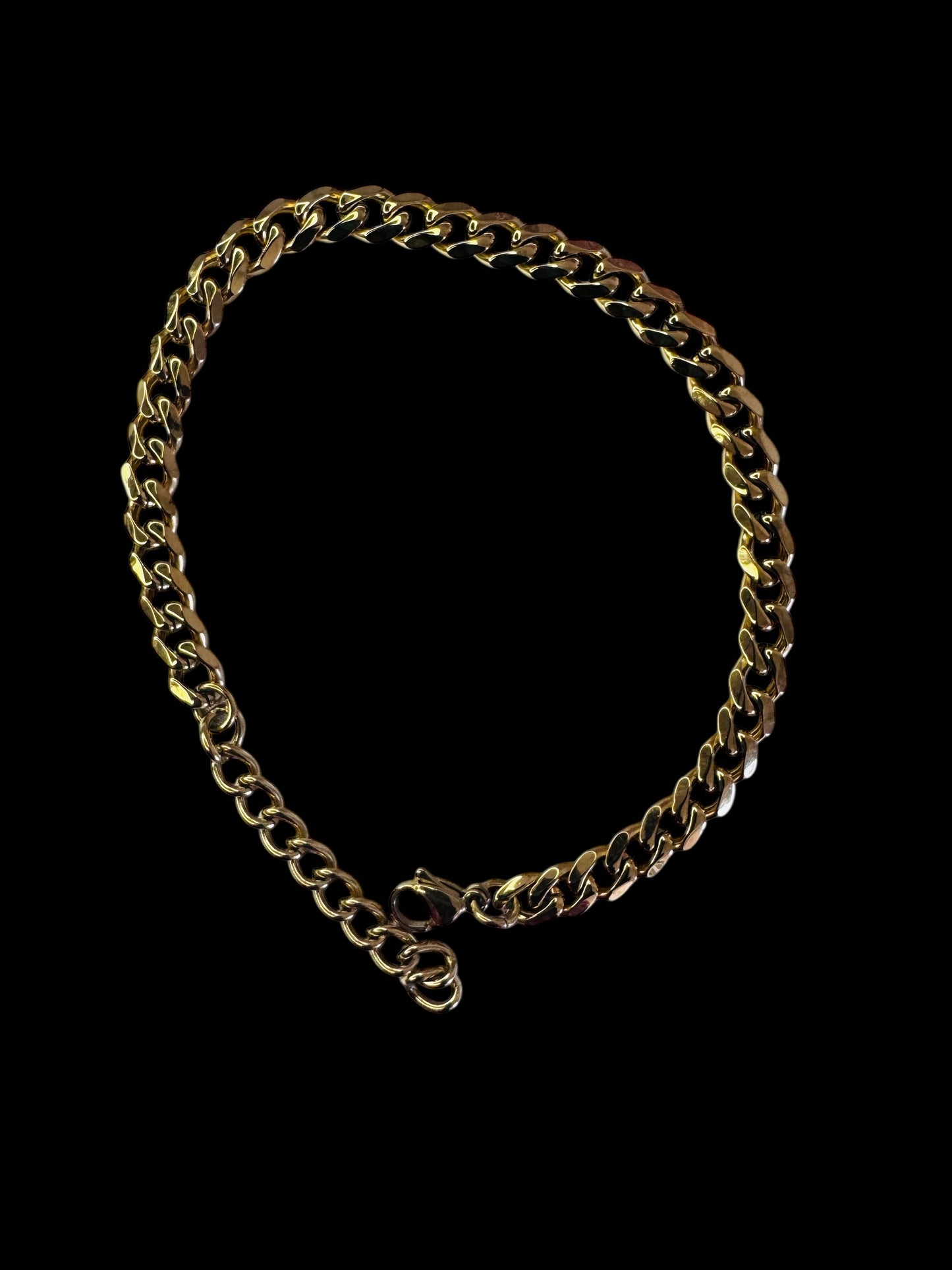 Gold chain anklet on a black background