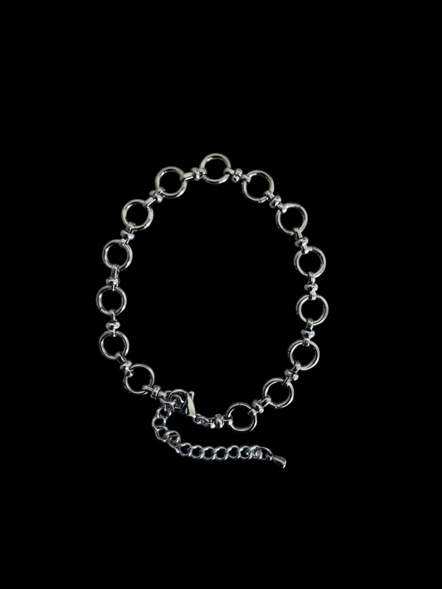 Silver chain anklet on a black background