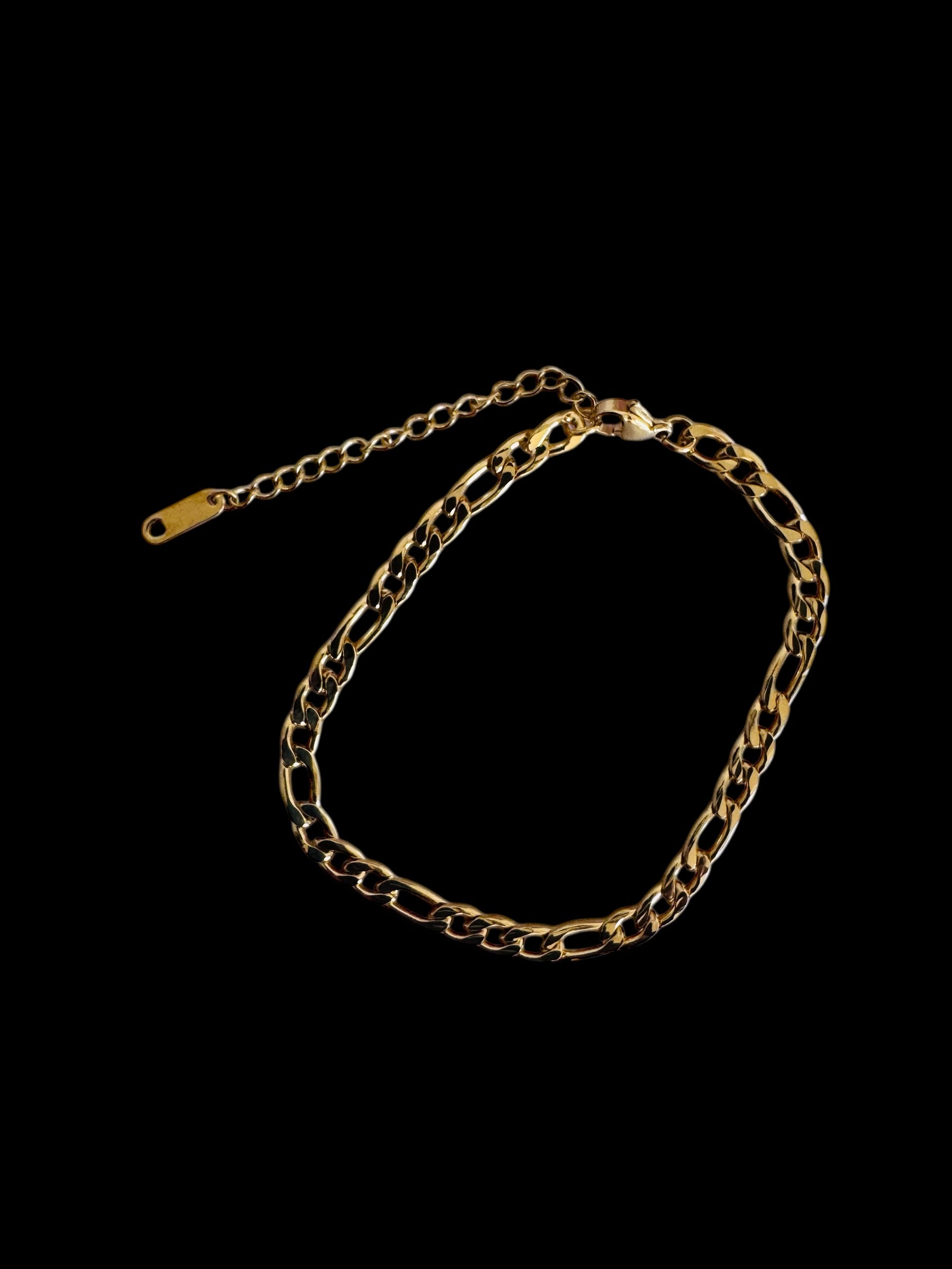 Gold figaro anklet on a black background