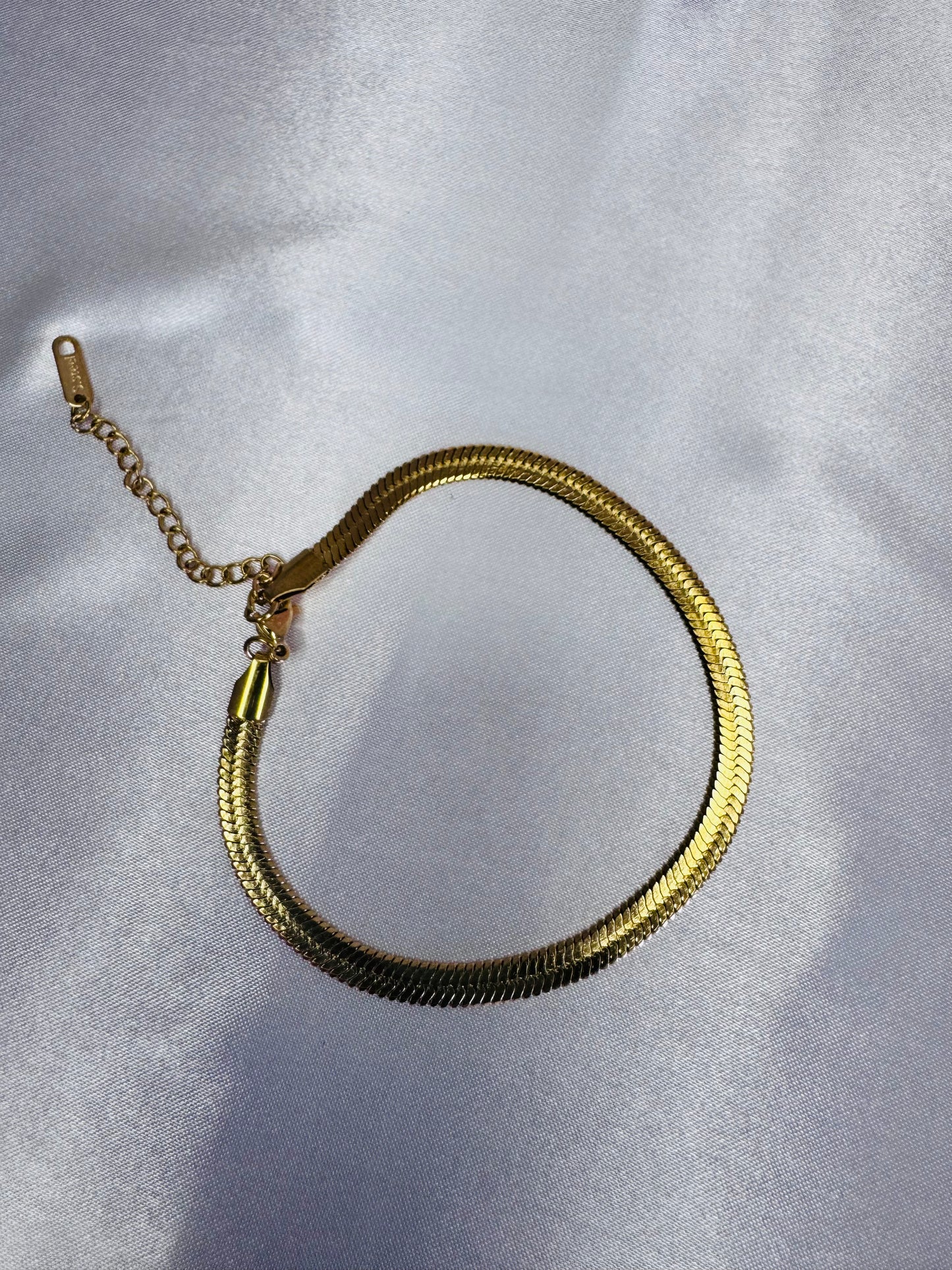 Gold chain necklace on a light gray background