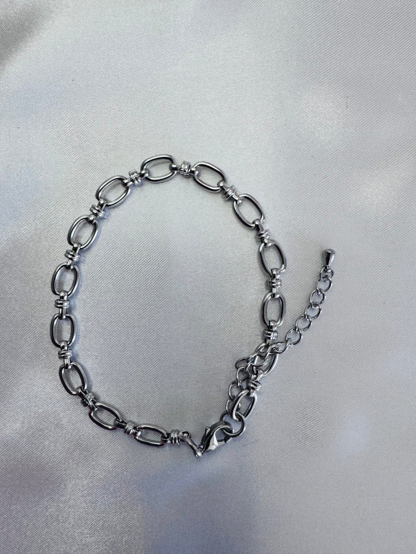 Silver anklet on a light gray background