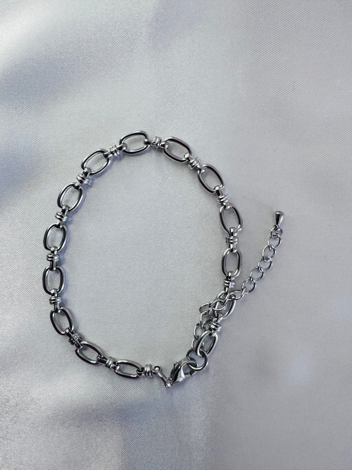 Silver anklet on a light gray background
