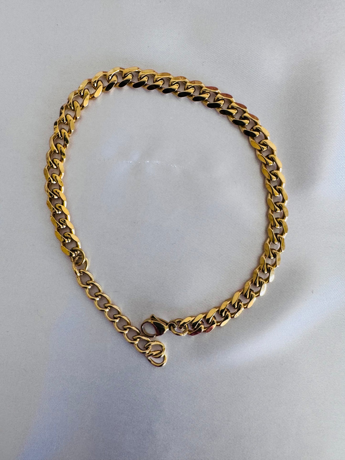 Gold anklet on a light gray background