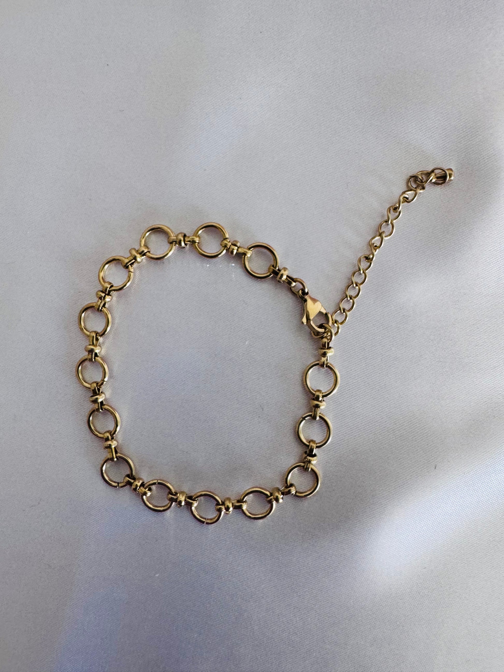 Gold chain anklet on a light gray background