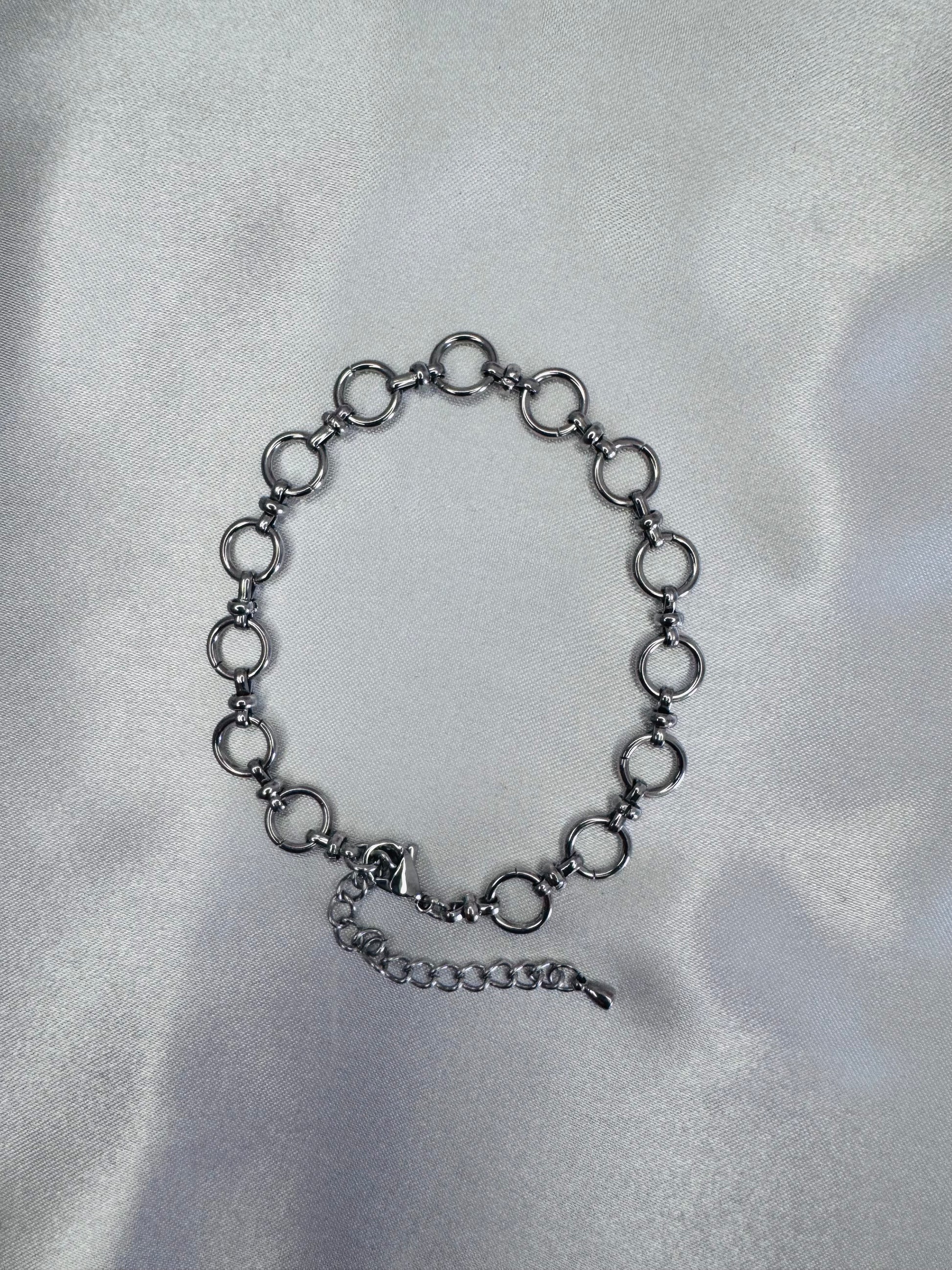 Black chain anklet  on a silver satin background