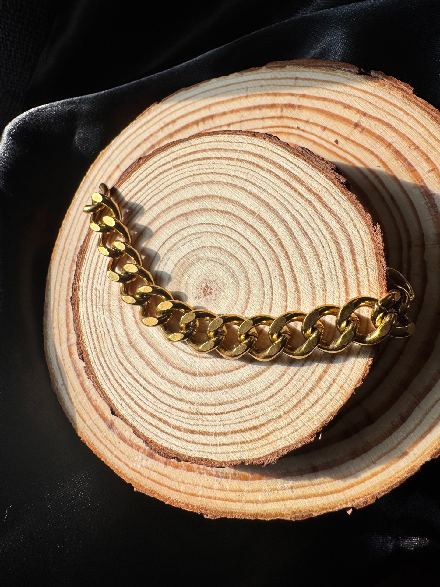 Gold chain anklet on a wooden surface