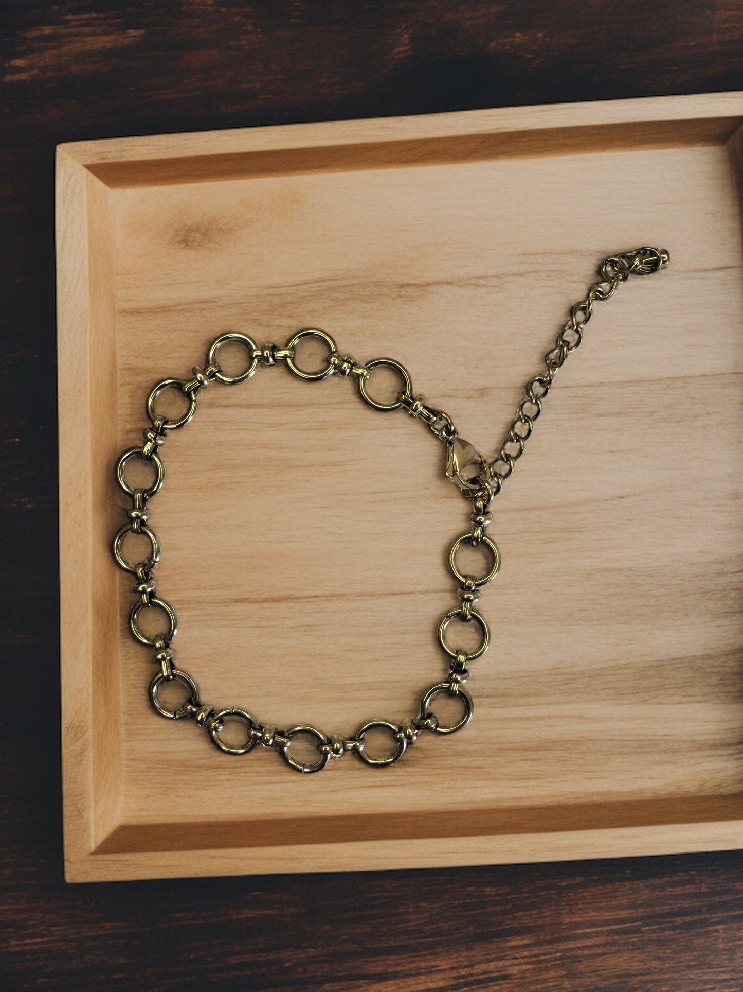 Gold chain anklet  on a wooden tray